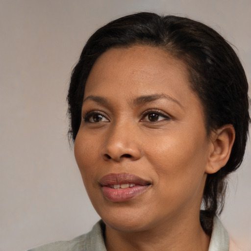 Joyful black adult female with medium  brown hair and brown eyes