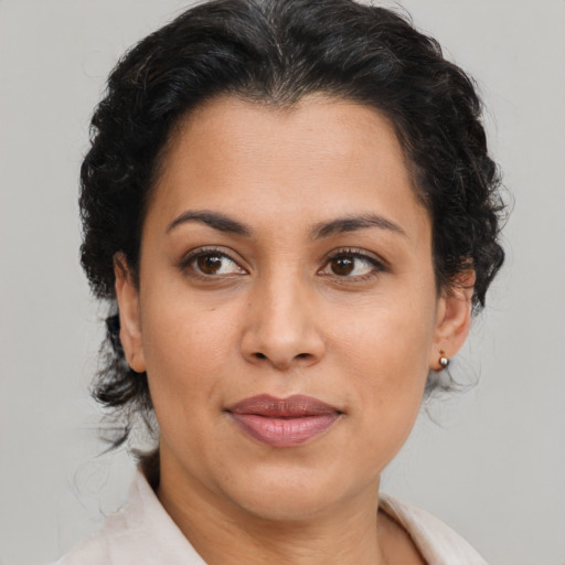 Joyful latino adult female with medium  brown hair and brown eyes