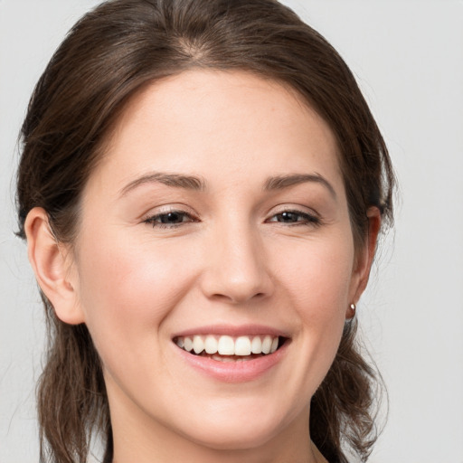 Joyful white young-adult female with medium  brown hair and grey eyes