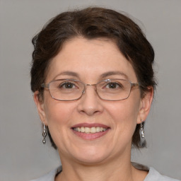 Joyful white adult female with medium  brown hair and grey eyes