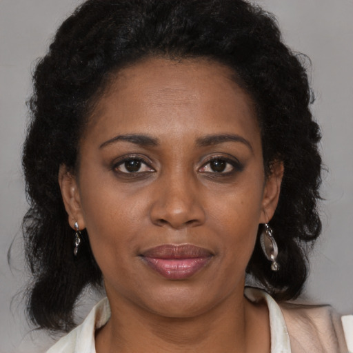 Joyful black adult female with medium  brown hair and brown eyes