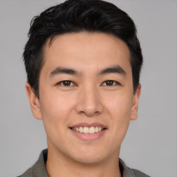 Joyful asian young-adult male with short  brown hair and brown eyes