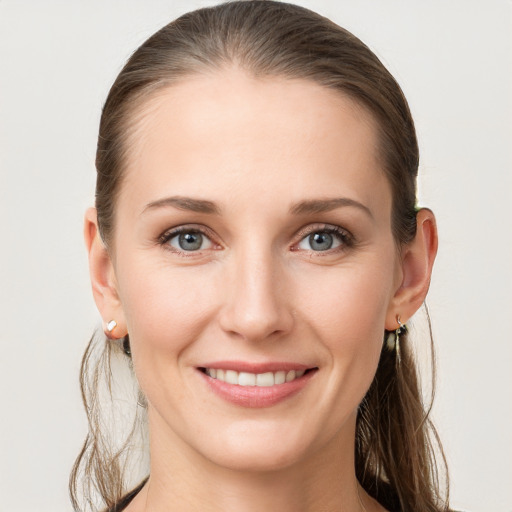 Joyful white young-adult female with long  brown hair and grey eyes