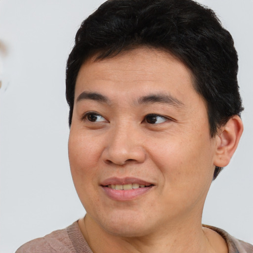 Joyful asian young-adult male with short  brown hair and brown eyes