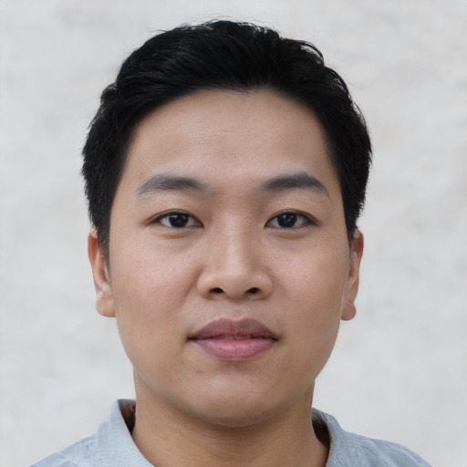 Joyful asian young-adult male with short  black hair and brown eyes