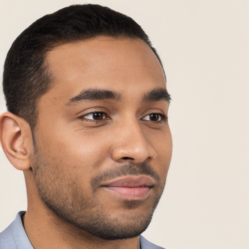 Joyful latino young-adult male with short  brown hair and brown eyes