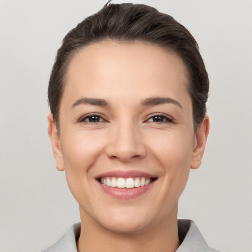 Joyful white young-adult female with short  brown hair and brown eyes