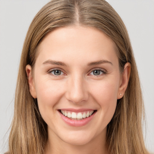 Joyful white young-adult female with long  brown hair and grey eyes