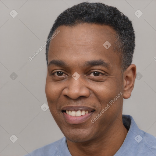 Joyful black young-adult male with short  black hair and brown eyes