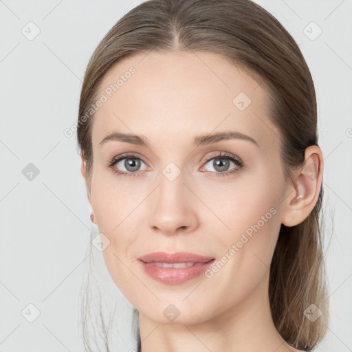 Joyful white young-adult female with medium  brown hair and grey eyes