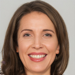 Joyful white adult female with medium  brown hair and brown eyes