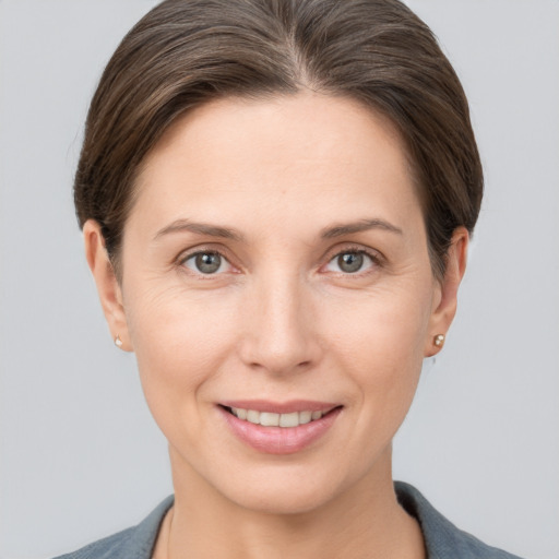 Joyful white young-adult female with short  brown hair and grey eyes