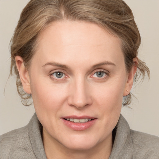 Joyful white adult female with medium  brown hair and blue eyes