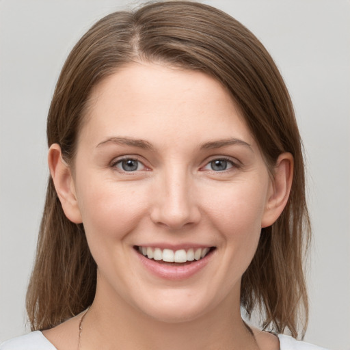 Joyful white young-adult female with medium  brown hair and grey eyes