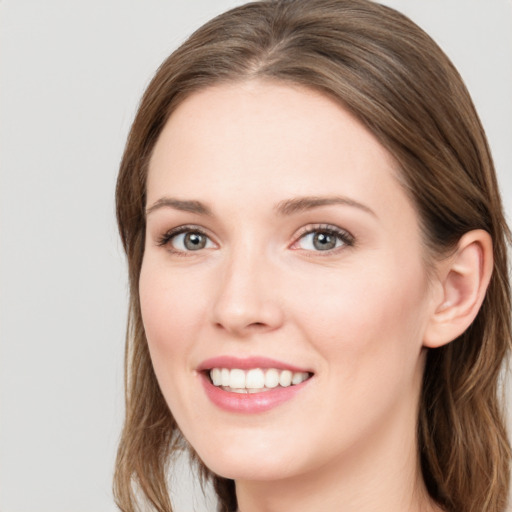 Joyful white young-adult female with long  brown hair and blue eyes