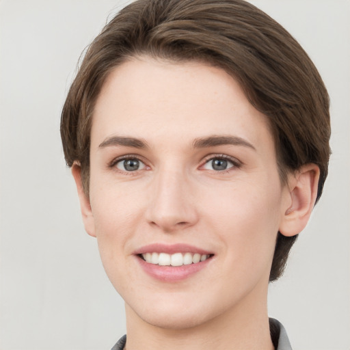 Joyful white young-adult female with short  brown hair and grey eyes