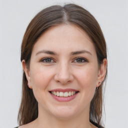 Joyful white young-adult female with medium  brown hair and grey eyes