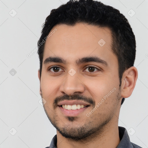 Joyful latino young-adult male with short  black hair and brown eyes