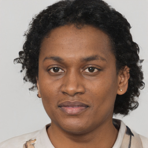 Joyful black adult female with short  black hair and brown eyes