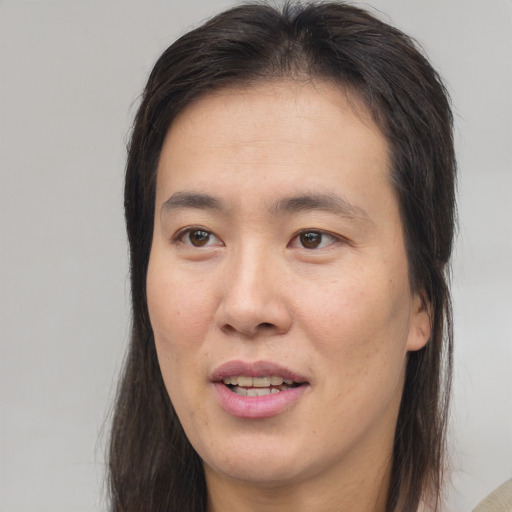 Joyful white adult female with long  brown hair and brown eyes