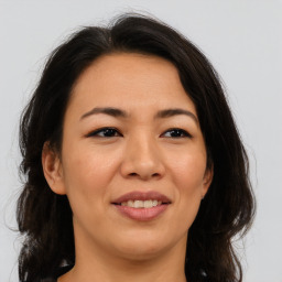 Joyful asian adult female with long  brown hair and brown eyes