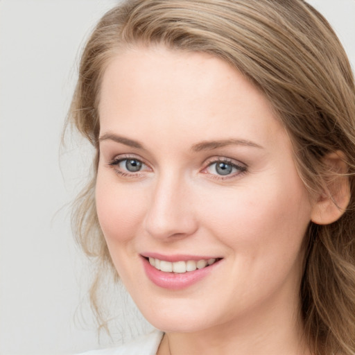 Joyful white young-adult female with long  brown hair and blue eyes