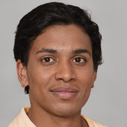 Joyful latino young-adult male with short  brown hair and brown eyes