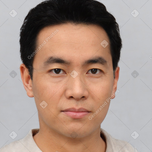 Joyful asian young-adult male with short  black hair and brown eyes