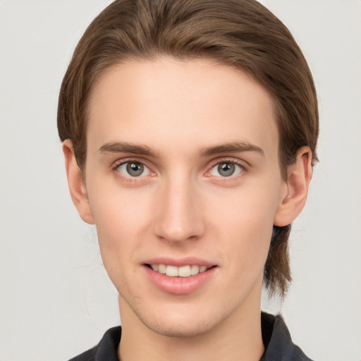 Joyful white young-adult male with short  brown hair and grey eyes