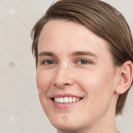 Joyful white young-adult female with medium  brown hair and grey eyes