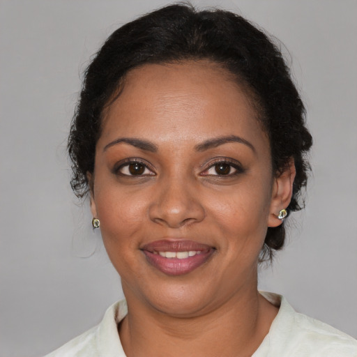 Joyful black adult female with short  brown hair and brown eyes