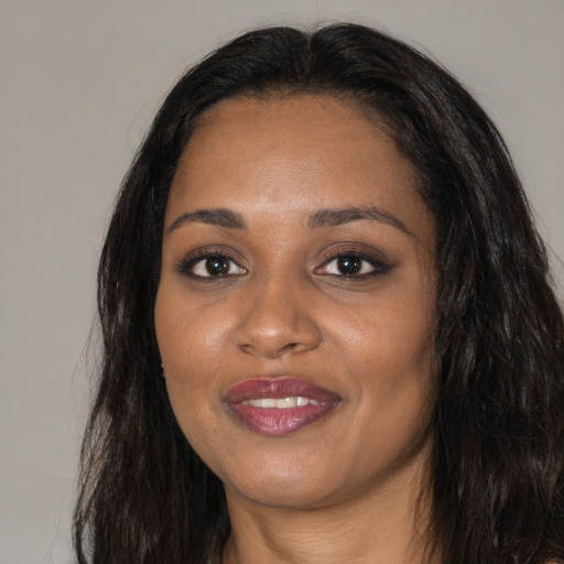 Joyful black young-adult female with long  black hair and brown eyes