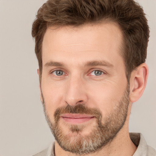 Joyful white adult male with short  brown hair and brown eyes