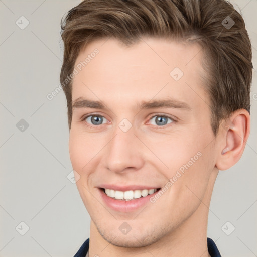 Joyful white young-adult male with short  brown hair and grey eyes