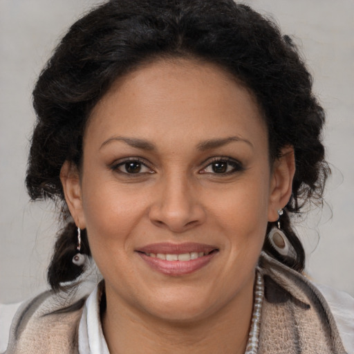 Joyful black adult female with long  brown hair and brown eyes