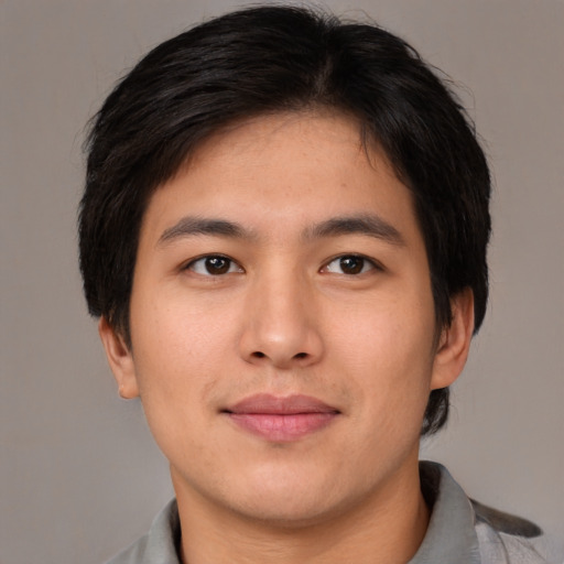 Joyful asian young-adult male with short  brown hair and brown eyes