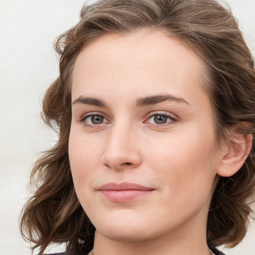 Joyful white young-adult female with long  brown hair and blue eyes