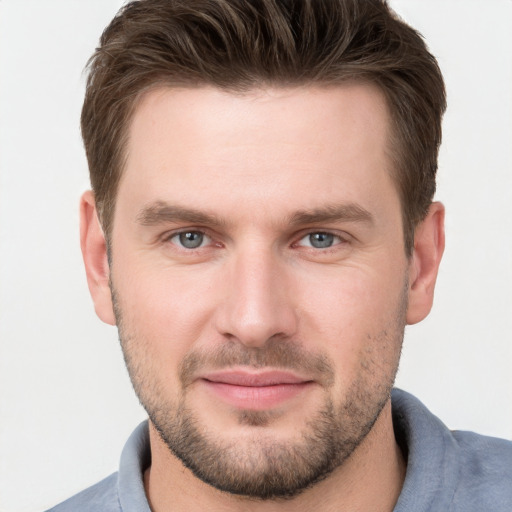 Joyful white young-adult male with short  brown hair and grey eyes