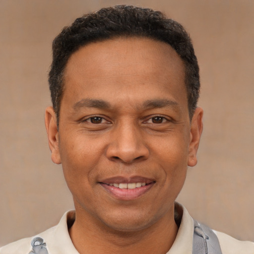 Joyful latino adult male with short  brown hair and brown eyes
