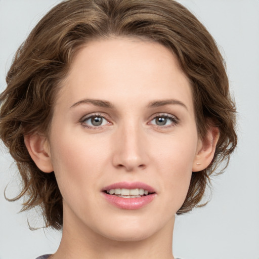 Joyful white young-adult female with medium  brown hair and green eyes