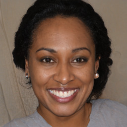 Joyful black adult female with medium  brown hair and brown eyes