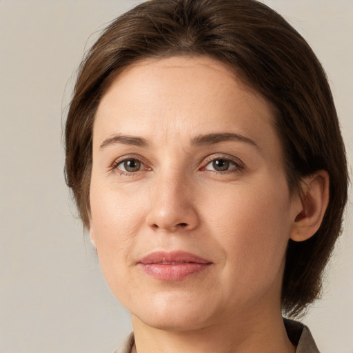 Joyful white young-adult female with medium  brown hair and grey eyes