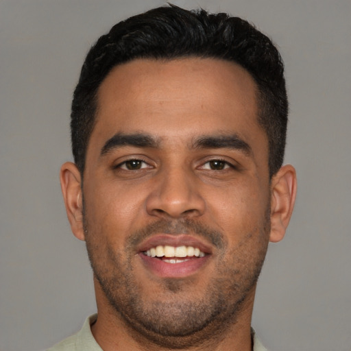 Joyful latino young-adult male with short  black hair and brown eyes