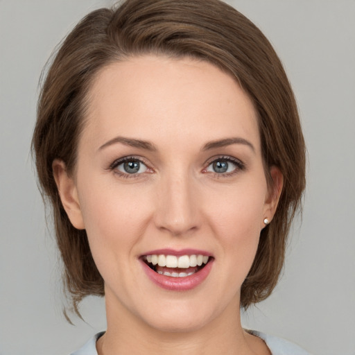 Joyful white young-adult female with medium  brown hair and green eyes