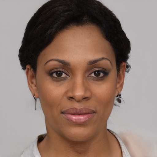 Joyful black young-adult female with short  brown hair and brown eyes