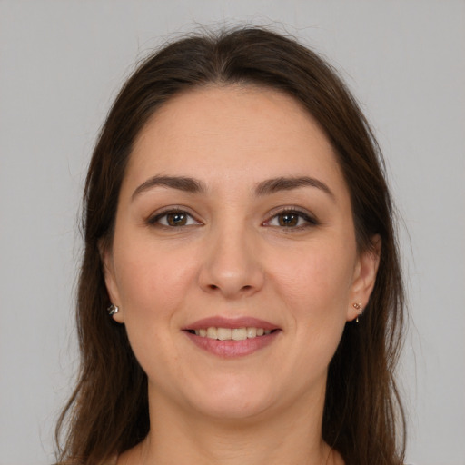 Joyful white young-adult female with long  brown hair and brown eyes