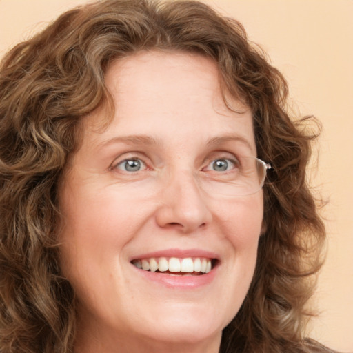 Joyful white adult female with long  brown hair and green eyes