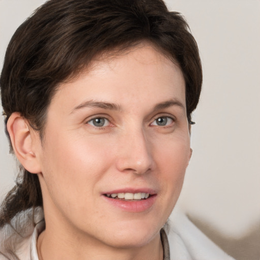 Joyful white young-adult female with medium  brown hair and grey eyes