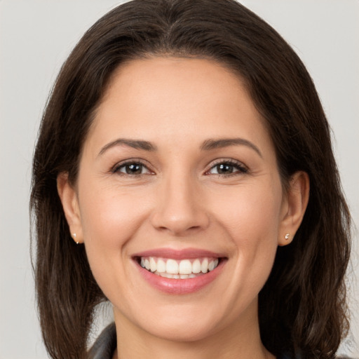 Joyful white young-adult female with long  brown hair and brown eyes