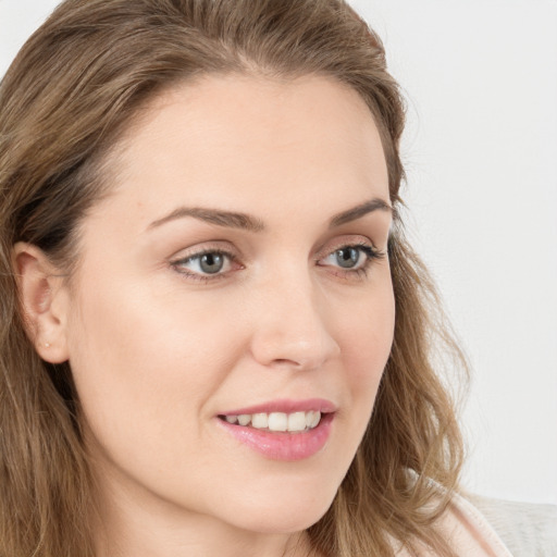 Joyful white young-adult female with long  brown hair and blue eyes